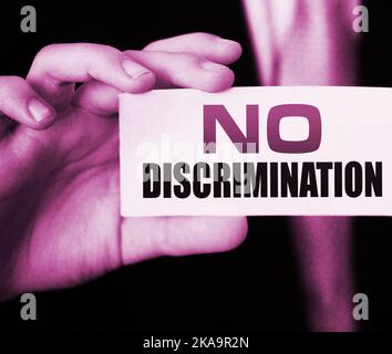 No discrimination words on a card in businessman hand. Social concept against racial and gender discrimination at work Stock Photo