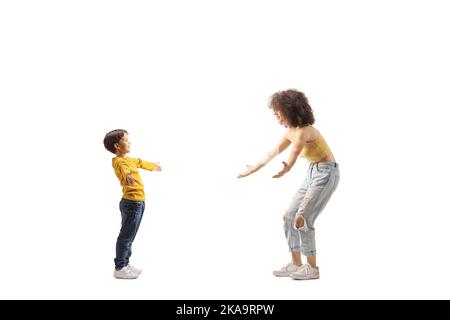 Full length profile shot of a boy and young female walking towards each other with arms wide open isolated on white background Stock Photo