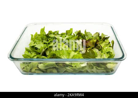 Green fresh salad leaves in glass baking tray. Isolated on white background with clipping path Stock Photo