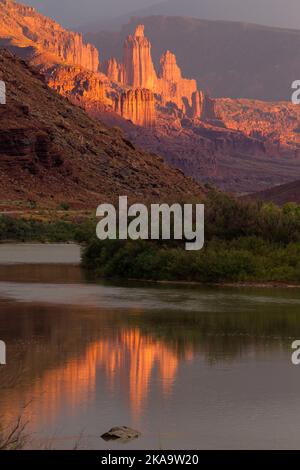 Storm clouds and sunset light on the Fisher Towers over the Colorado River near Moab, Utah. Stock Photo
