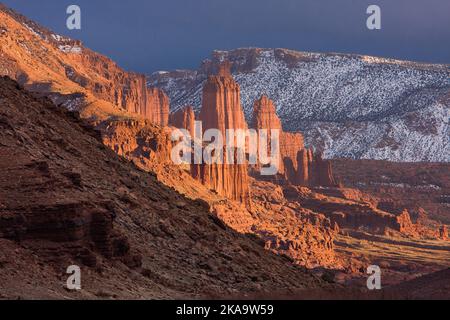 Fisher Towers at sunset in winter with the La Sal Mountains behind.  Near Moab, Utah. Stock Photo