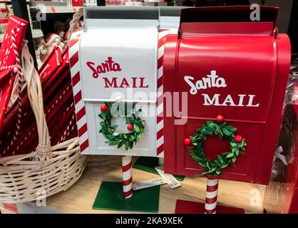 Santa Mail. Red and white mailboxes with green wreaths for letters to Santa Claus. Christmas decorations. Stock Photo