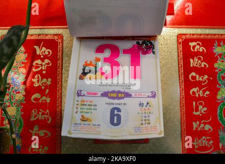 Moscow, Russia, November 2019: Detachable tear-off Vietnamese calendar with new year eve, date December 31 on the wall: red and pink numbers, hierogly Stock Photo