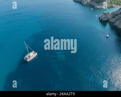 Aerial view of a catamaran moored near Porto Timoni. Corfu, Greece. Crystal clear sea. Coastline of the island. Stock Photo