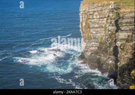 Rugged sea cliffs that guard the Kitchener memorial tower at Marwick Head, dedicated to Field Marshal Earl Kitchener and crew of the HMS Hampshire Stock Photo
