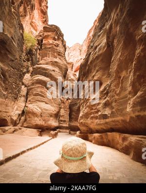 Tourist in Petra take photograph of The Siq, the narrow slot-canyon that serves as the entrance passage to the hidden city of Petra. Sightseeing desti Stock Photo