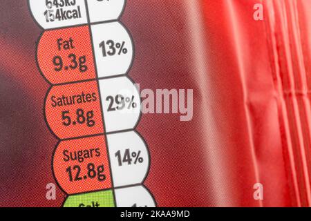 Close-up Tesco brand dark chocolate soft plastic film food packaging with dietary nutrition traffic light box with food fat content & high in sugar. Stock Photo