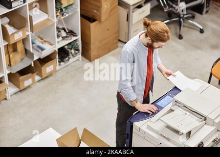 Top view at young man using copying machine at industrial shop, copy space Stock Photo