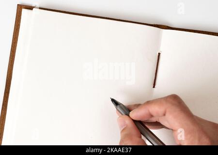 Blank notebook with hand holding pen Stock Photo
