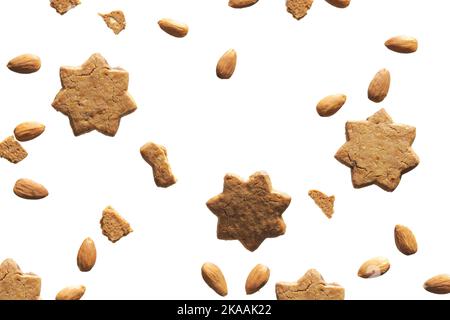 Levitation of star cookies on off white background. Cinnamon cookies, almond nuts and broken cookie pieces levitating, flying around. Abstract white Stock Photo
