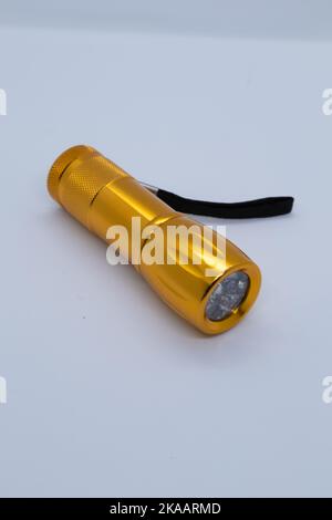 Small orange flashlight on white background Stock Photo
