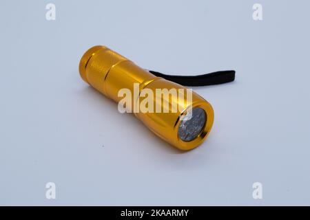 Small orange flashlight on white background Stock Photo