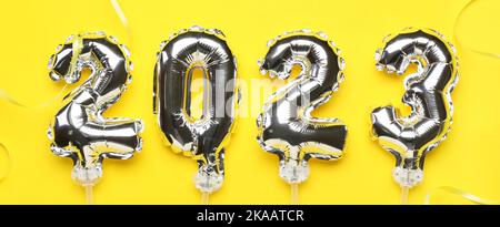 Figure 2023 made of silver balloons on yellow background Stock Photo