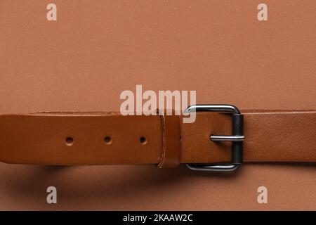 Leather belt with buckle on brown background Stock Photo