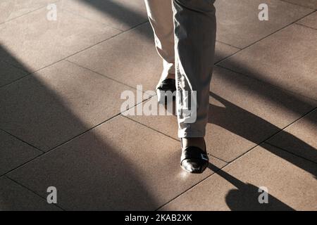 feet of people hurrying in the airport with sown shadows Stock Photo