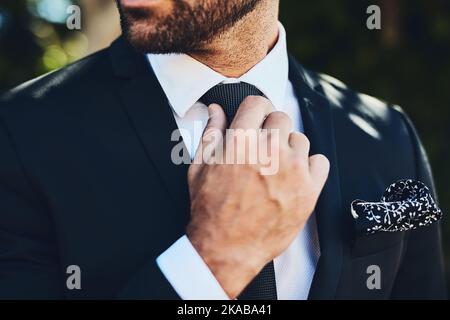 I make sure I look good. an unrecognizable man adjusting his tie outside. Stock Photo