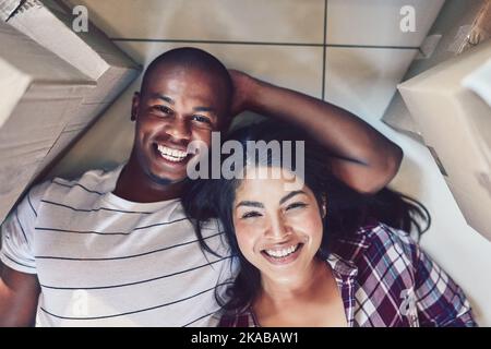 This is our new happy place. Portrait of a young couple taking a break while moving house. Stock Photo