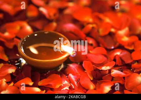 Happy Diwali, Clay Diya lamps lit during Diwali, Hindu festival of lights. Colorful traditional oil lamp diya, flower decoration. Stock Photo