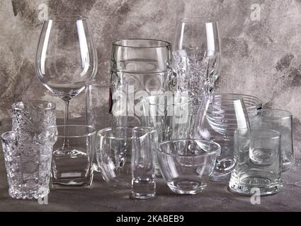 Set of glasses of different sizes and for different drinks on gray biton background Stock Photo