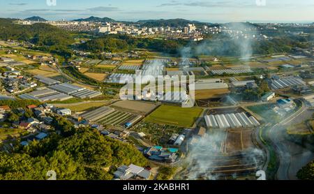 Smoke from controlled burns rises over rural farming community Stock Photo
