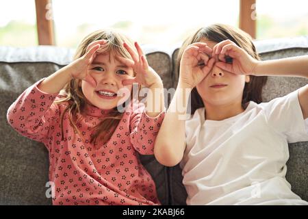 We see you. Portrait of two adorable little siblings bonding together at home. Stock Photo