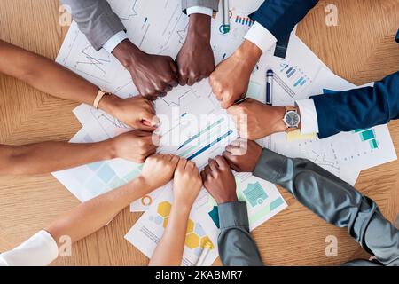 Teamwork, documents and circle of hands in fist in business meeting for strategy, planning and analytics. Collaboration, diversity and business people Stock Photo