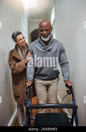 Right by your side as we grow older. a senior woman helping her husband to walk with his walker. Stock Photo
