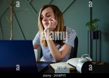Working from home concept. Exhausted woman working remotely with laptop at home office workplace Stock Photo