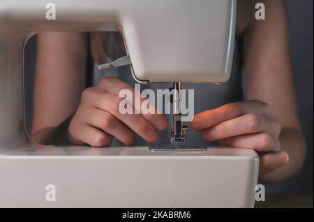 Sewing needle threader tool in use and a single black string Stock Photo -  Alamy