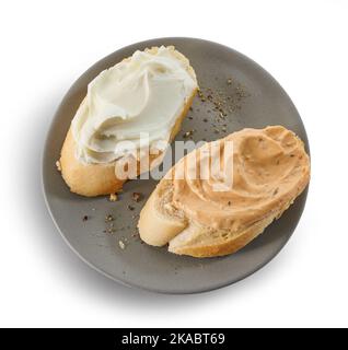 two baguette slices with cream cheese on grey plate isolated on white background, top view Stock Photo