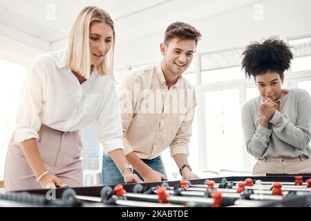 Business people, foosball table and competition in office for team building, motivation and teamwork in startup company. Group diversity employees Stock Photo