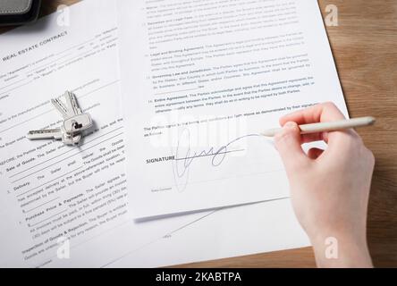 Minsk, Belarus - October 28 2021 Ral estate contract signature concept. Hand putting her sign on legal property agreement with pen. Stock Photo