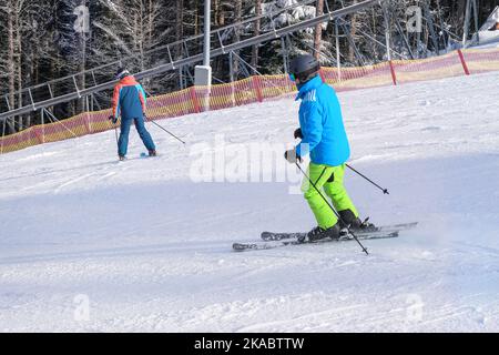 Sportsman goes downhill in winter. Ski sports in winter. Vacation in mountains in ski resort. Stock Photo