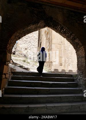 Woman walking through entrance gate at Ananuri Fortress, Georgia. High quality photo Stock Photo