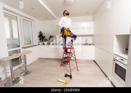 electrician installing led light bulbs in ceiling lamp Stock Photo