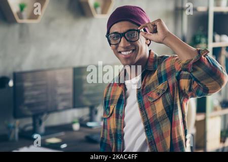 Photo of smiling cool businessman dressed hat glasses showing smiling front engineer work indoors workplace workstation loft Stock Photo