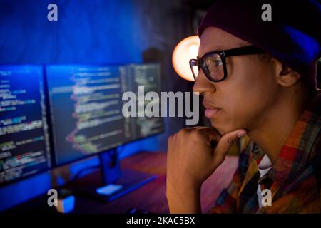 Profile close up portrait of minded clever cybersecurity expert hand touch chin hacking russian websites evening indoors Stock Photo
