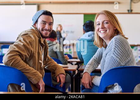 Education is a must. Rearview portrait of two young university students sitting in class during a lecture. Stock Photo