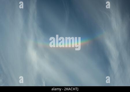 Cirrus clouds with colorful circumzenithal arc, a halop caused by refraction of sunlight through ice crystals high in the atmosphere. Stock Photo
