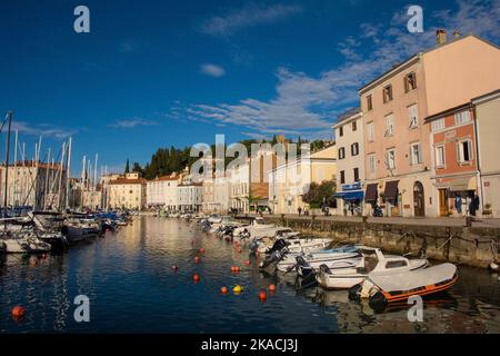 Piran, Slovenia - September 17th 2022. The harbour in the historic town of Piran in Slovenia. The town's defensive walls on the background hill Stock Photo