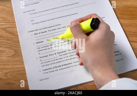 Minsk, Belarus - November 3, 2021 Hand reading contract and highlighting Seller word in agreement. Stock Photo