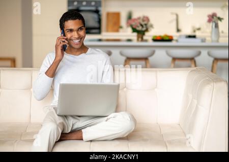 Young handsome dark-skinned man with a laptop Stock Photo