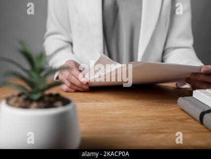 Reading and studying business contract concept. Woman with legal agreement in hands over office desk. Stock Photo