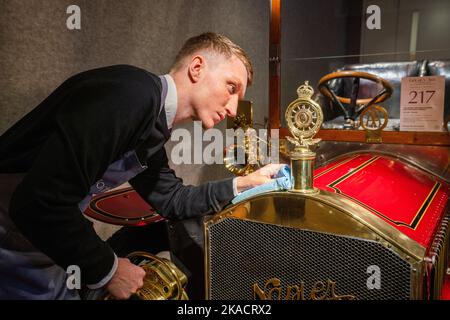 London UK. 2 November 2022.  An art handler polishes a 1904 Napier 15hp (Estimate: £275,000-350,000. Photocall for the Bonhams Golden Age of Motoring Sale featuring the oldest Daimler  and a former barn find Napier ‘supercar. The sale will take place on 4 November. Credit: amer ghazzal/Alamy Live News Stock Photo