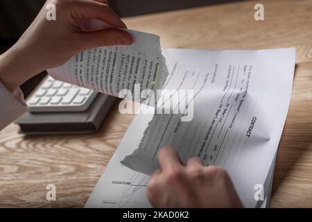 Minsk, Belarus - November 2, 2021 Contract terminated concept. Hands breaching and ripping legal business agreement. Stock Photo