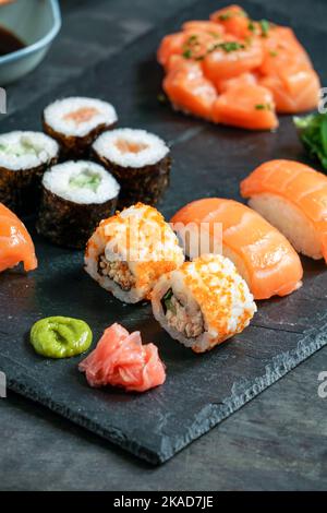 Sushi Set nigiri and sushi rolls, on black stone slate on black background Stock Photo