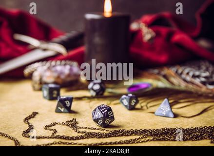 Fantasy role play board game still life concept. Selective focus on dice. Background decorated with various character objects tools. Stock Photo
