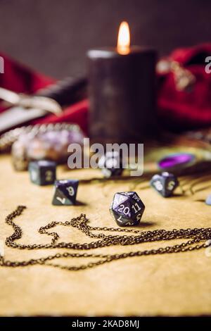 Fantasy role play board game still life concept. Selective focus on dice. Background decorated with various character objects tools. Stock Photo