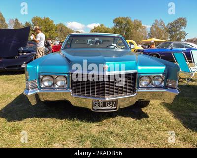 Old blue luxury Cadillac DeVille sedan four door 1970 in the countryside. Front view. Grill. Nature, grass, trees. Classic car show. Stock Photo