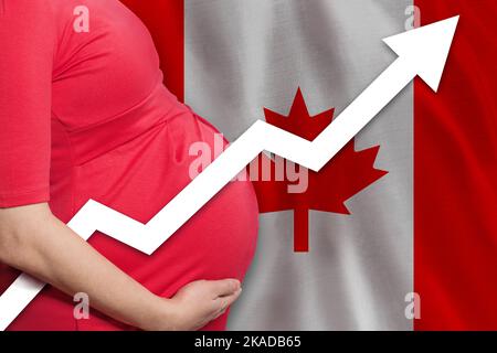 Canadian pregnant woman on flag of Canada background. Birth rate up Stock Photo